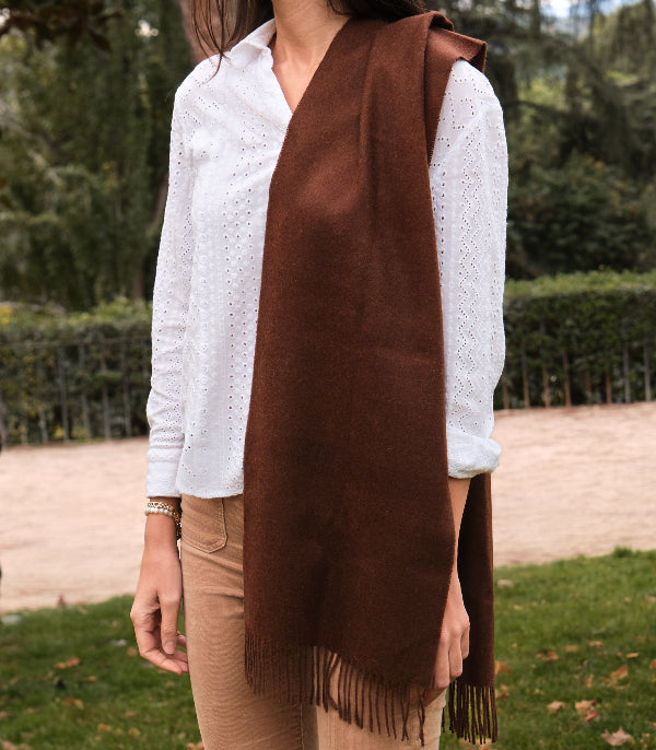 Modelo femenina en la naturaleza con una bufanda lisa de baby alpaca color chocolate