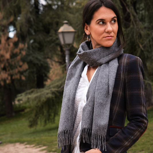 Modelo morena con una bufanda de baby alpaca color gris