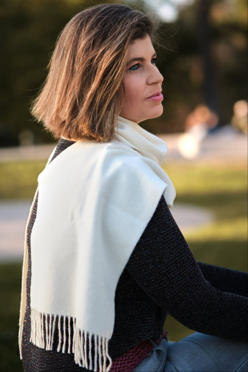 Modelo femenina con una bufanda de baby alpaca blanca