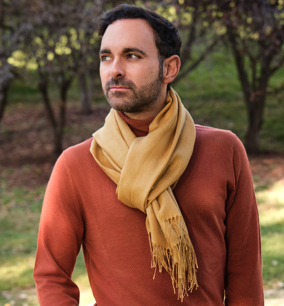Modelo masculino con chal liso de baby alpaca y seda color miel mostaza