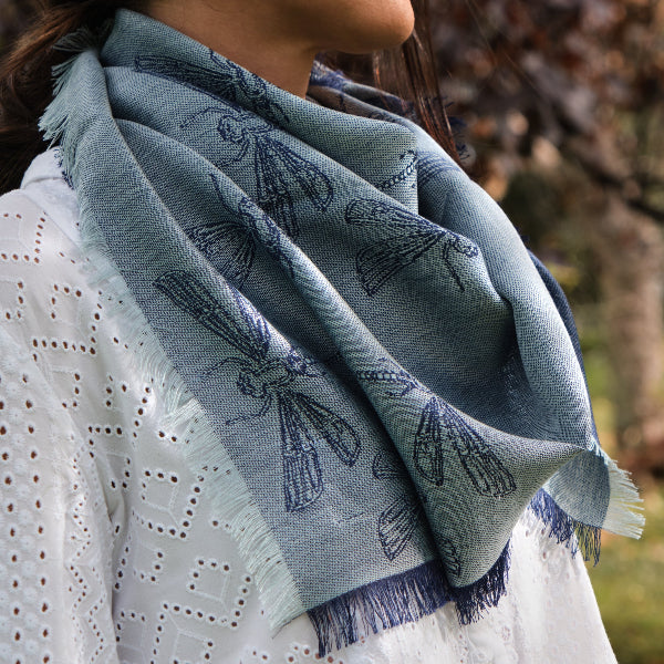 Detalle de pañuelo azul de baby alpaca y seda con diseños de libélulas
