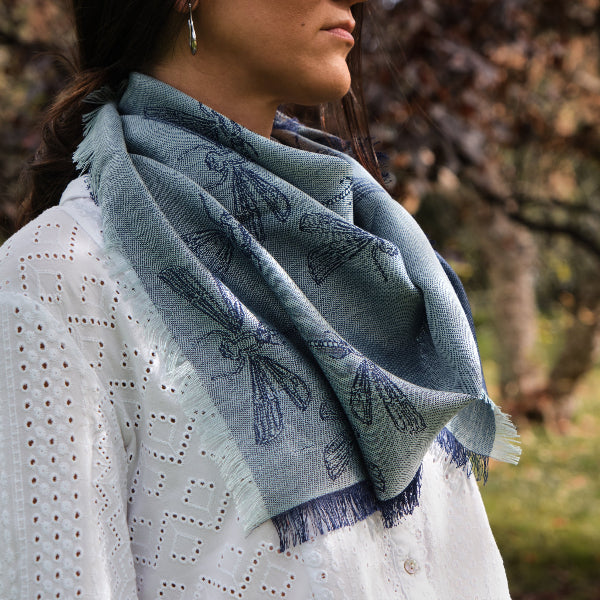 Modelo femenina con un pañuelo color azul de baby alpaca y seda al cuello