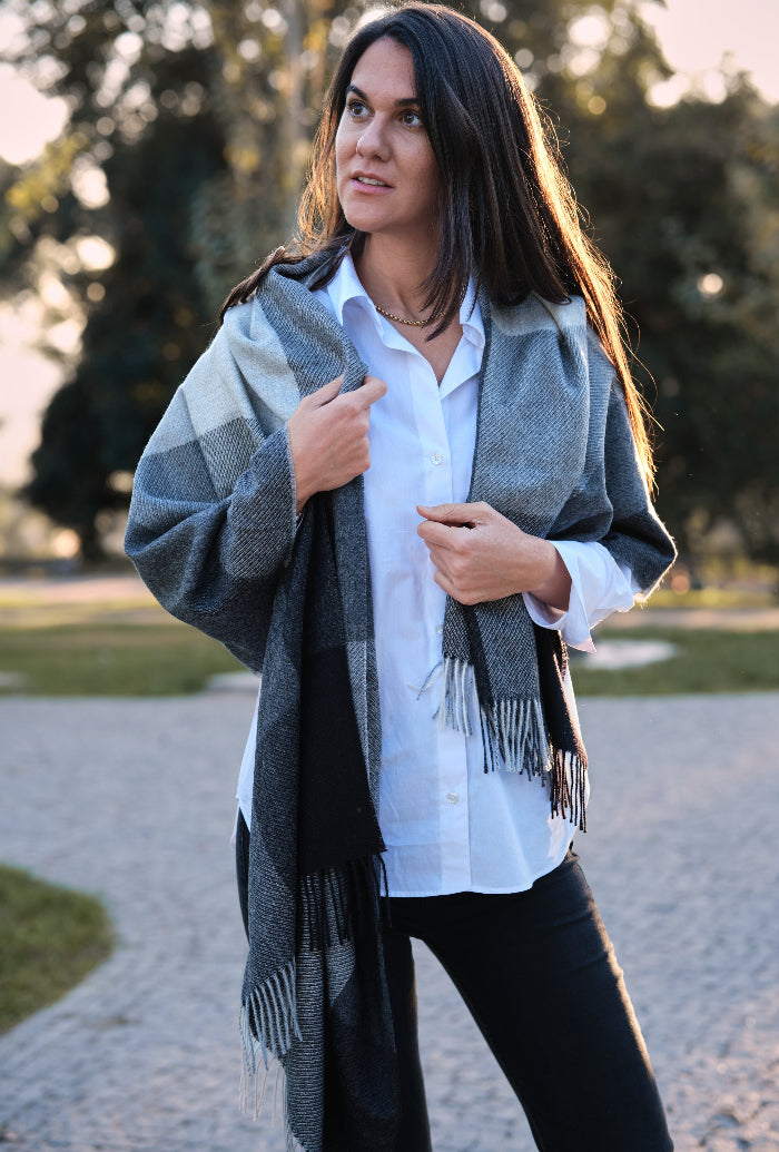 Mujer con un chal de baby alpaca de colores grises