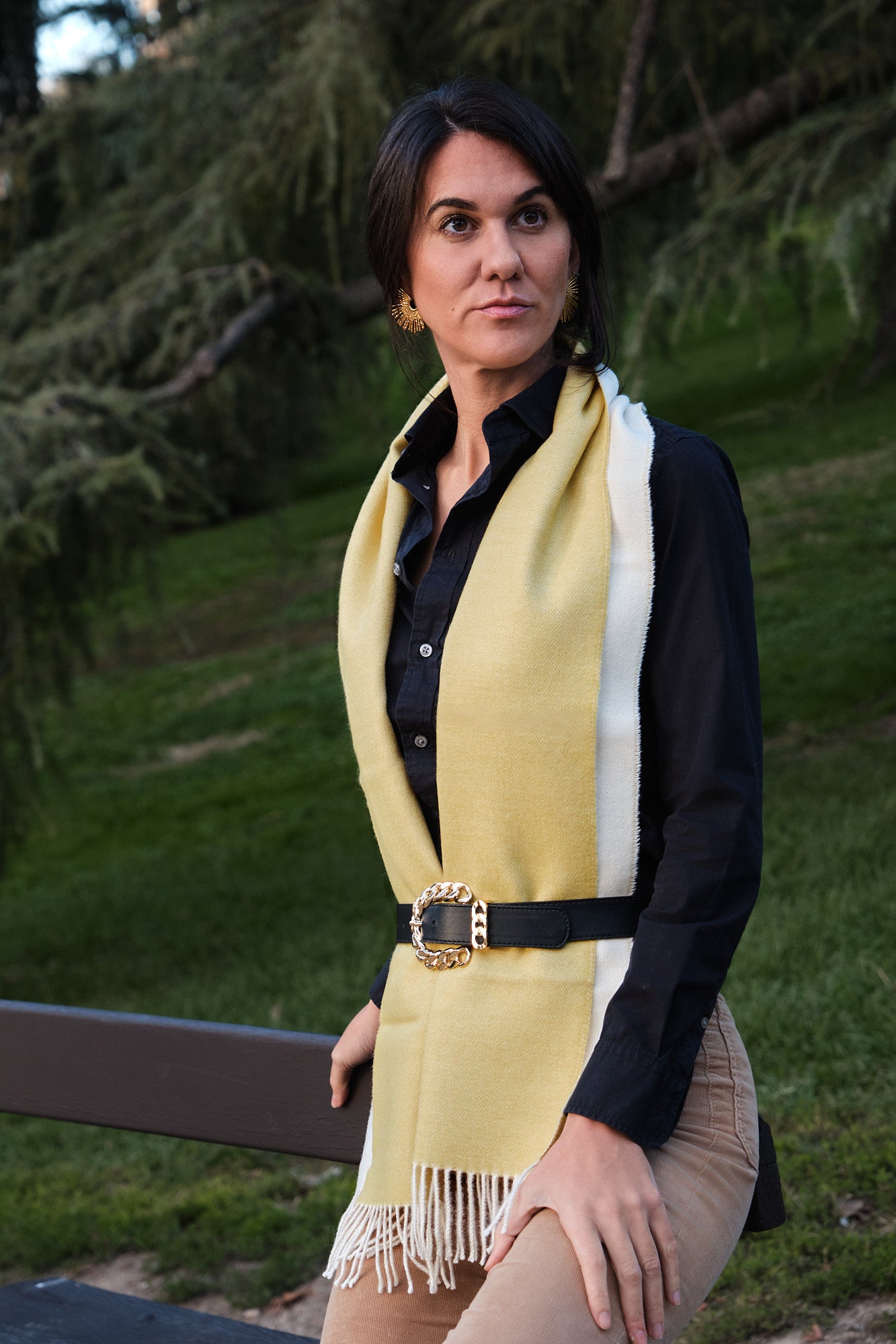 Mujer en el campo con una bufanda de baby alpaca al cello de color amarillo y blanco