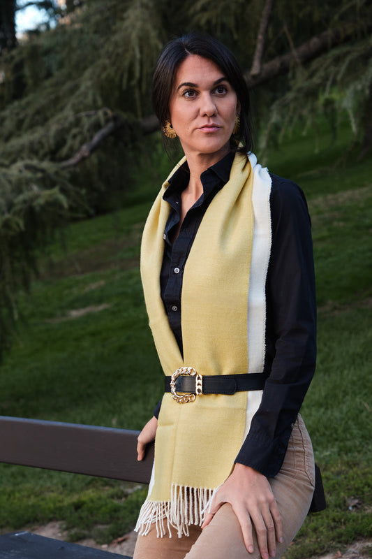 Mujer en el campo con una bufanda de baby alpaca al cello de color amarillo y blanco