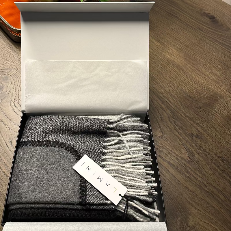 Chal de cuadros con bolsillos en tonos grises de LAMINI fabricado en de lana de baby alpaca dentro de su caja