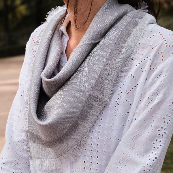 Detalle de pañuelo de baby alpaca y seda color gris con diseños de libélulas